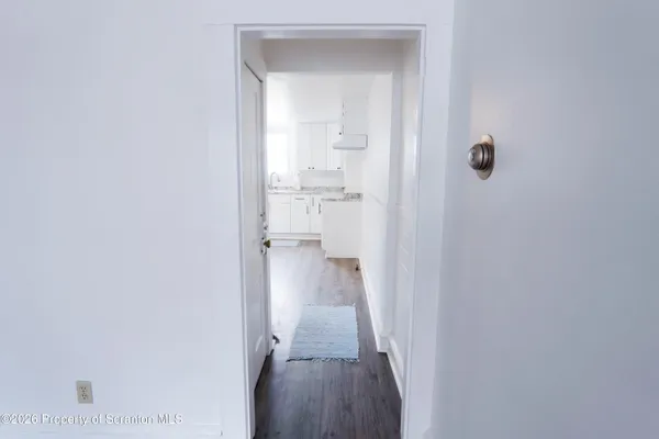 a view of a hallway with a livingroom and a bathroom
