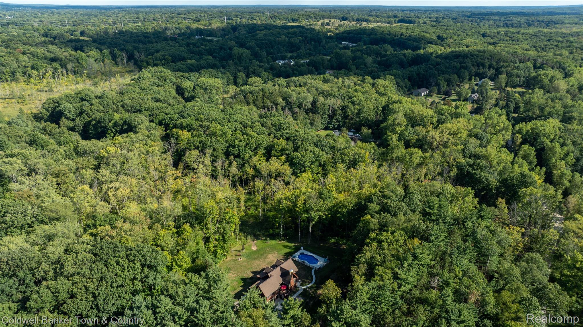 7023 Munsell Road Howell, MI 48843 - Photo 52 of 55 Expansive wooded acreage featuring a private residence with a visible pool and surrounding landscaping