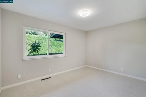 an empty room with windows and closet