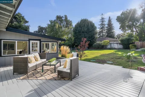 a view of house with a big yard and large trees