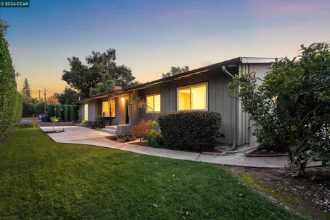 a front view of a house with a yard and trees