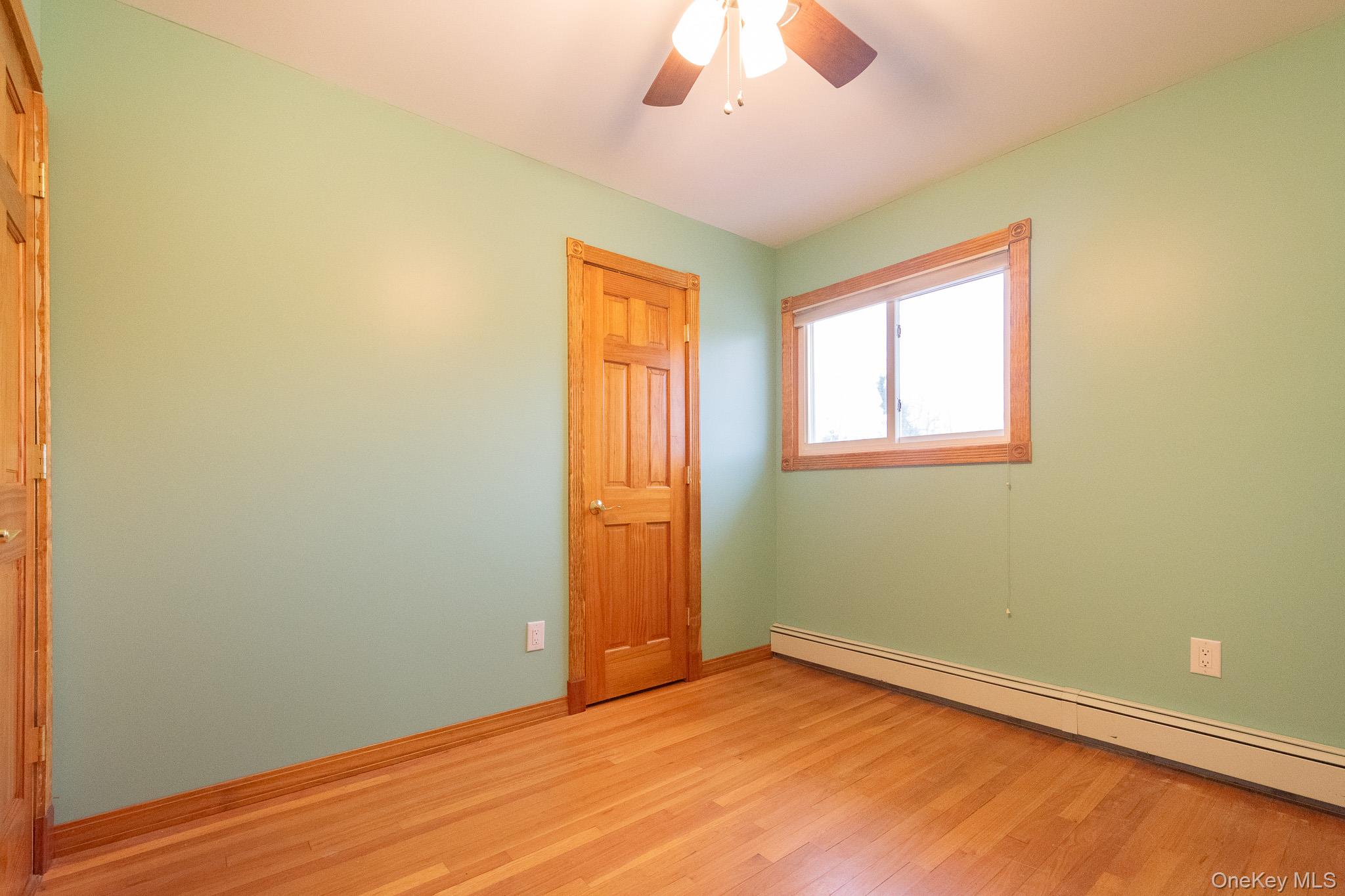 4 Manchester Drive Bethpage, NY 11714 - Photo 14 of 26 a view of an empty room with wooden floor and a window