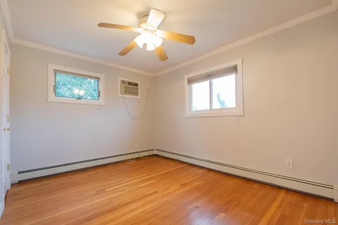 a view of a room with wooden floor and a ceiling fan