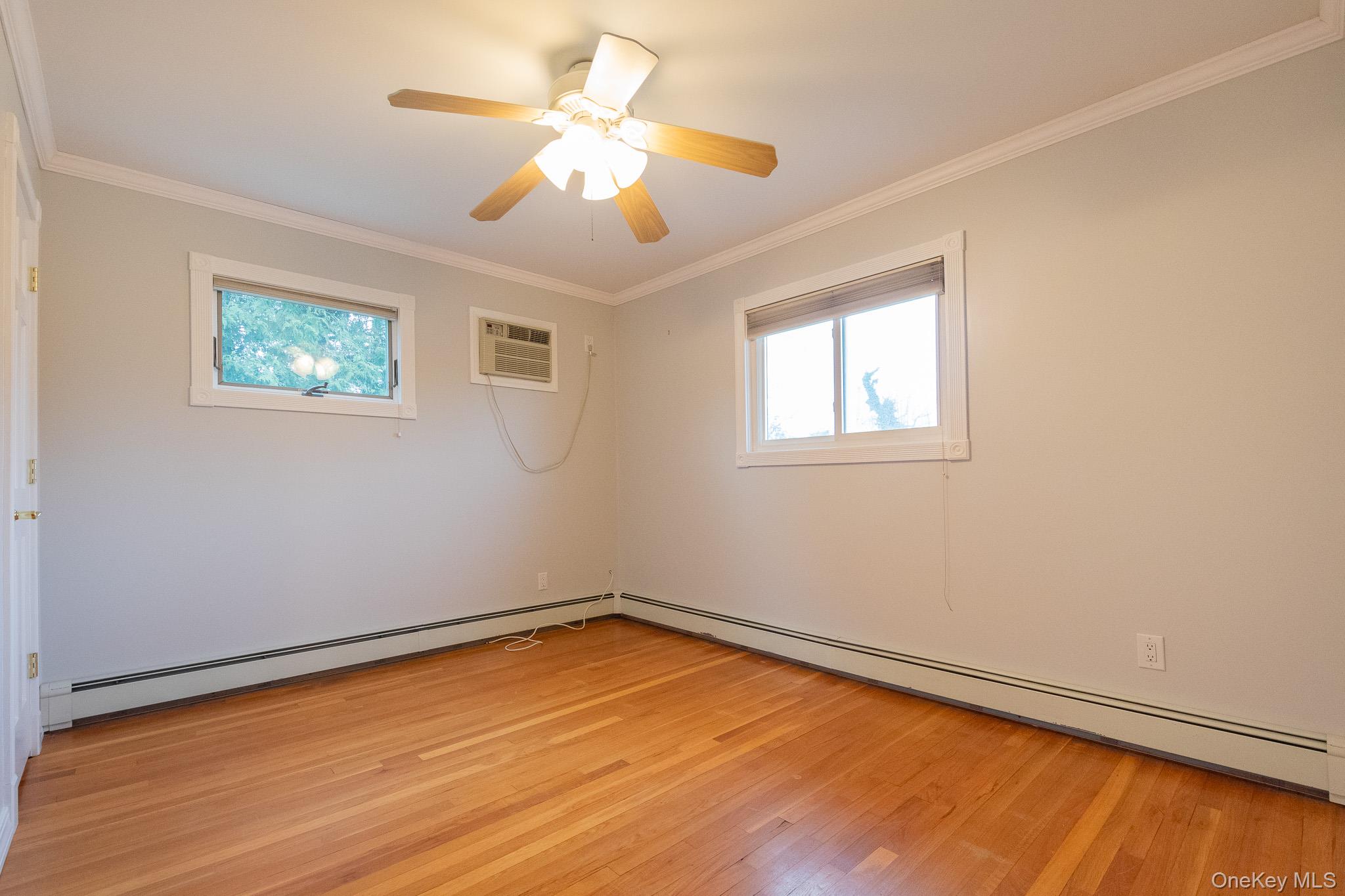 4 Manchester Drive Bethpage, NY 11714 - Photo 15 of 26 a view of a room with wooden floor and a ceiling fan