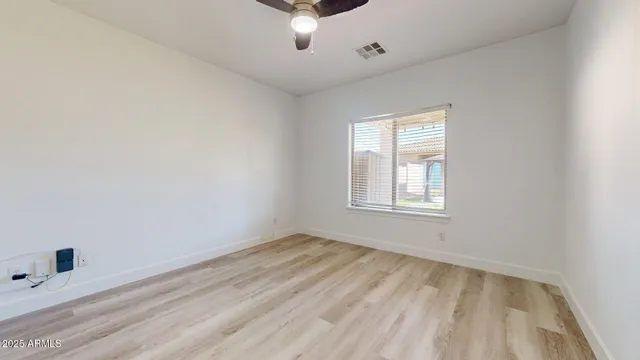 an empty room with a window and a ceiling fan