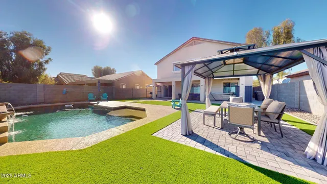 a view of a patio with table and chairs under an umbrella