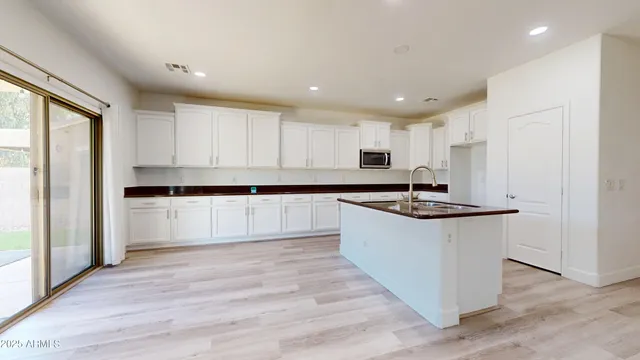 a large kitchen with hardwood floor and a sink