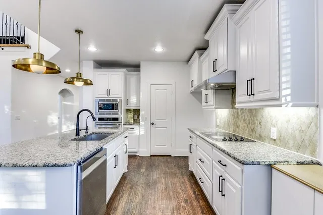 a kitchen with stainless steel appliances granite countertop a sink stove and refrigerator