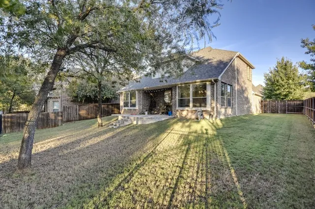 a view of a house with backyard and a tree