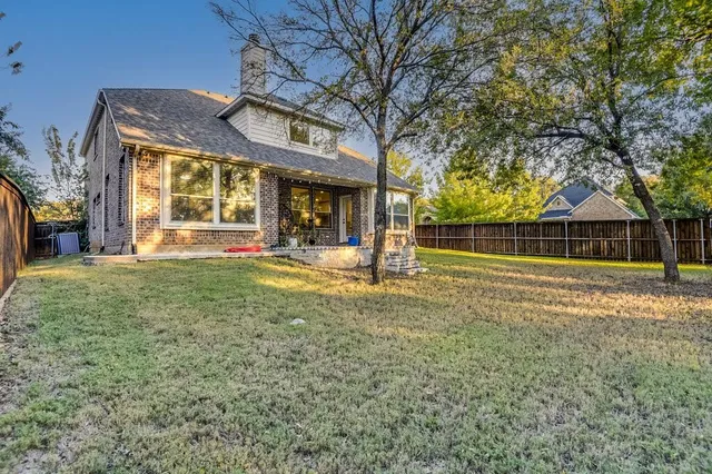 a view of a house with a big yard and large trees