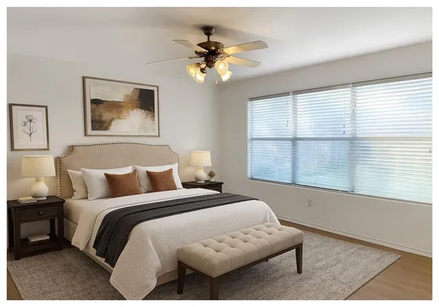 a bedroom with a bed and a window with a potted plant on a table