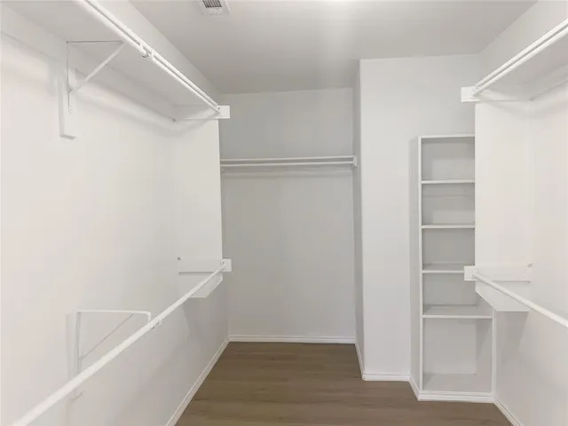 a view of walk in closet with empty racks