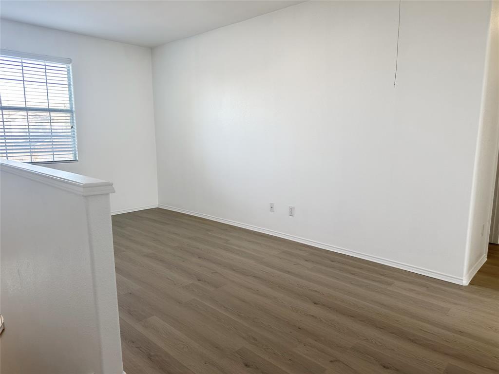 7537 Lazy Spur Boulevard Fort Worth, TX 76131 - Photo 9 of 24 an empty room with wooden floor and windows