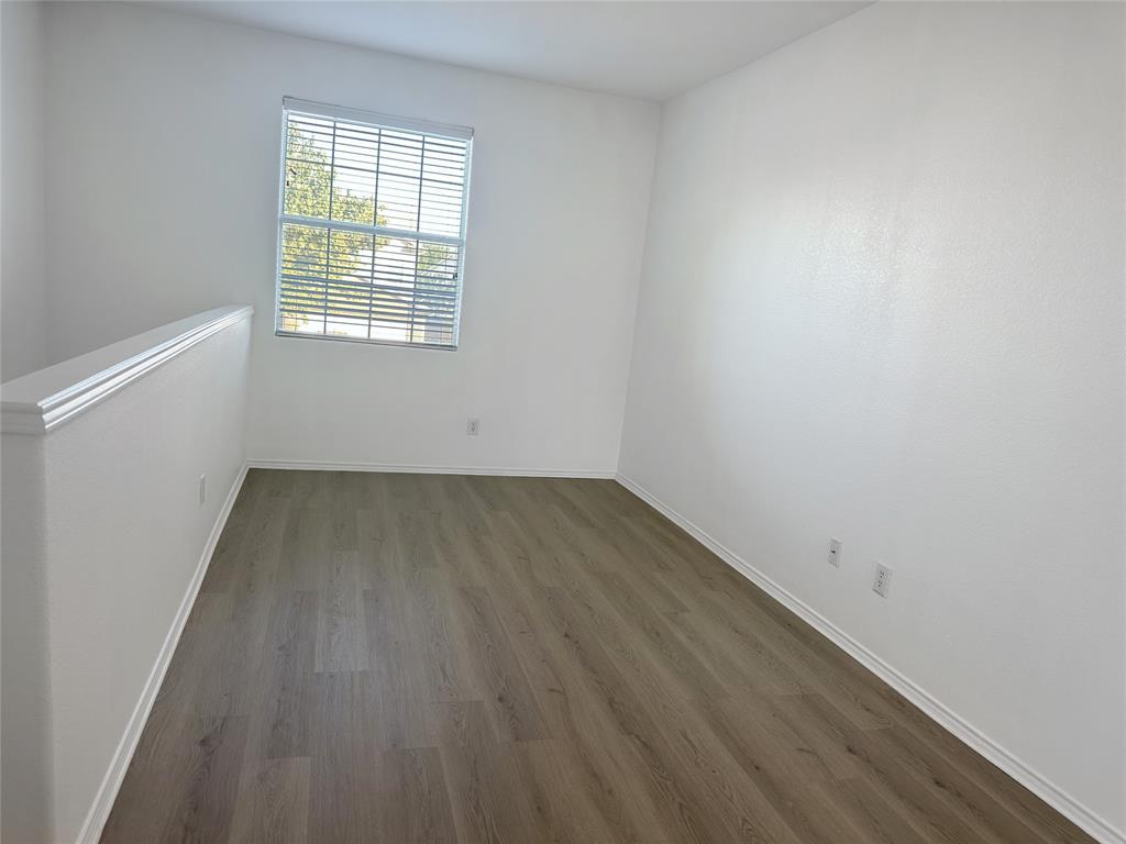 7537 Lazy Spur Boulevard Fort Worth, TX 76131 - Photo 10 of 24 an empty room with wooden floor and windows