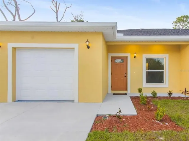a view of a room with a large window and potted plants