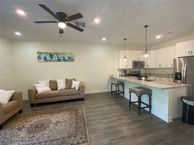a living room with kitchen island furniture and a chandelier