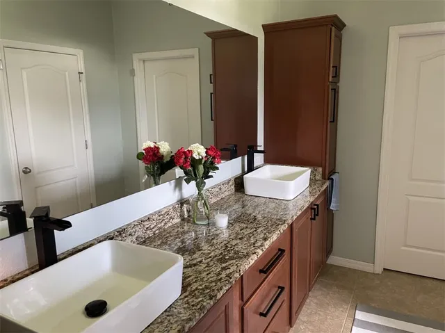 a bathroom with a granite countertop sink and a mirror