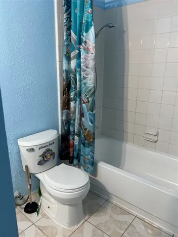 a white toilet sitting next to a bath tub