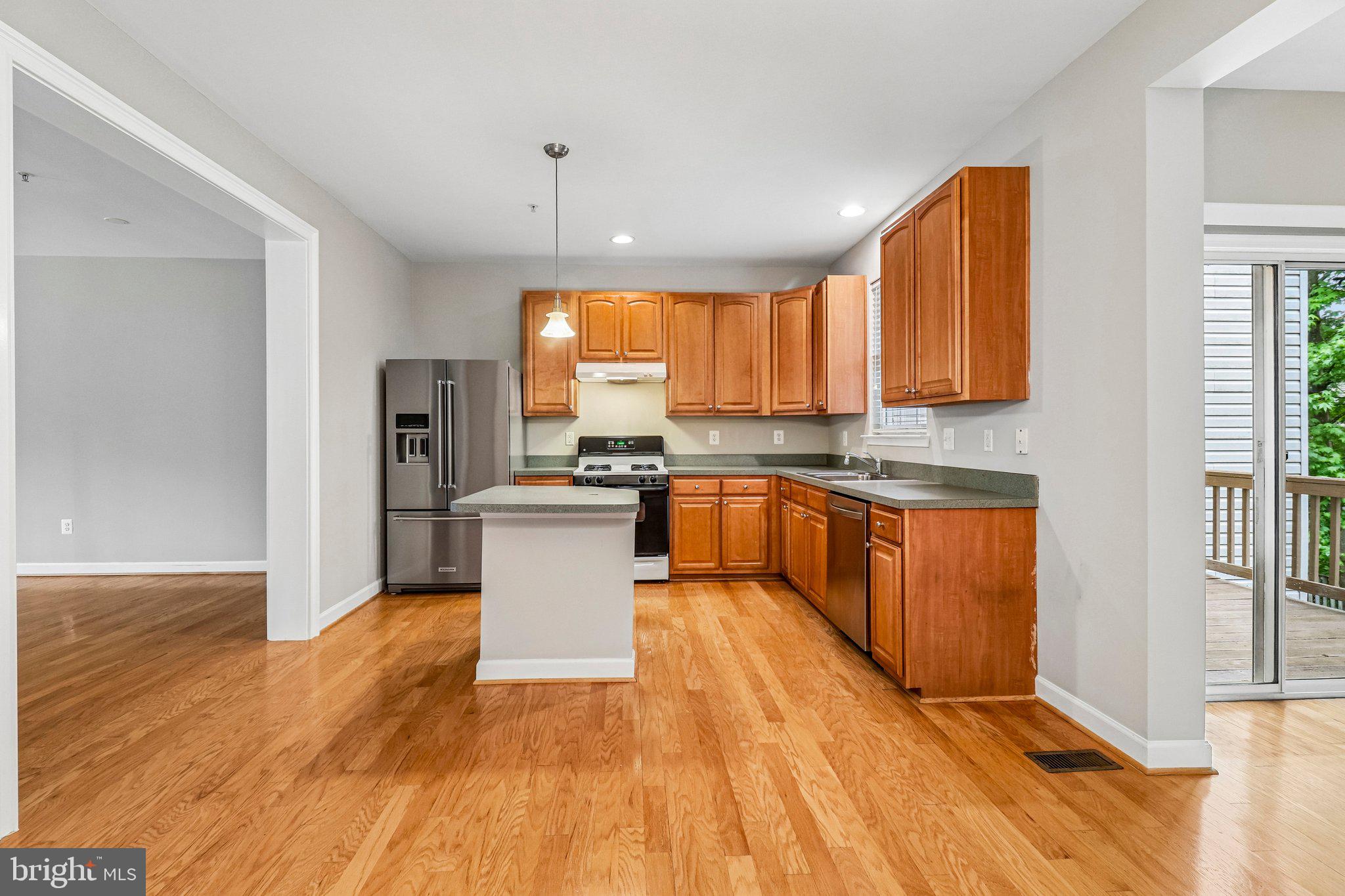 217 Braxton Way, Unit 217 Edgewater, MD 21037 - Photo 7 of 27 a large kitchen with stainless steel appliances granite countertop a stove a sink dishwasher and a refrigerator with wooden floor