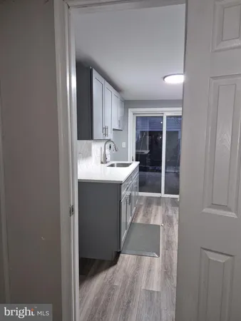 a kitchen with cabinets and wooden floor