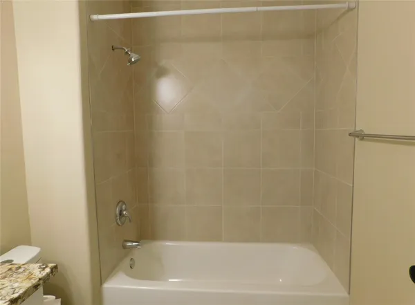 a bathroom with a granite countertop sink a toilet and bathtub
