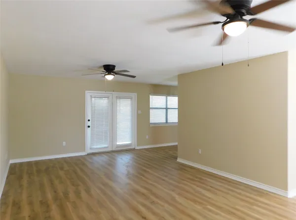 a view of a room with wooden floor and windows