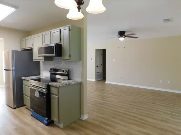 a kitchen with a sink stove and cabinets
