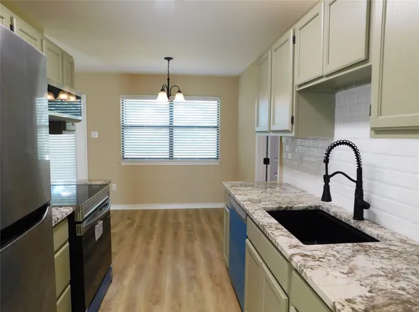 a kitchen with white cabinets a sink and dishwasher