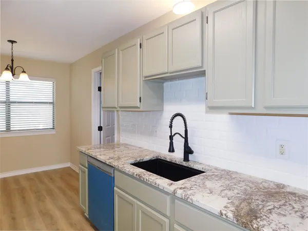 a kitchen with granite countertop a stove top oven and refrigerator