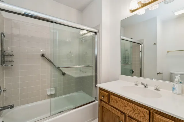 a bathroom with a granite countertop sink mirror and a bathtub