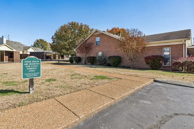 a front view of a house with a yard and potted plants