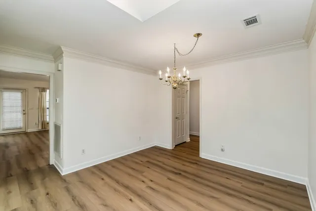 a view of a room with wooden floor and chandelier