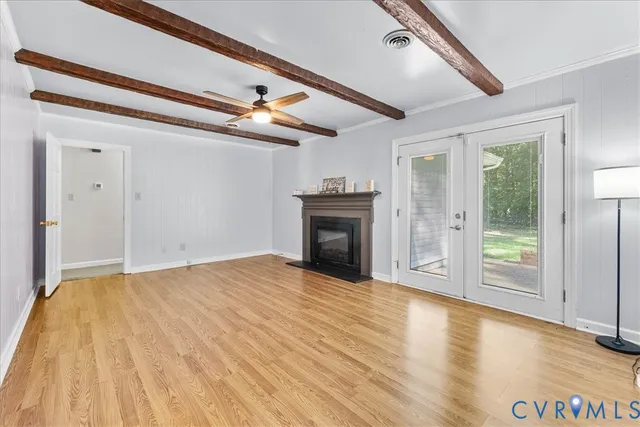 a view of empty room with wooden floor and fireplace