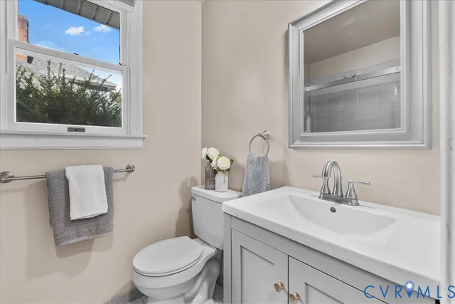 a bathroom with a toilet a sink and mirror