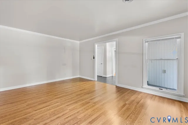 a view of an empty room with wooden floor