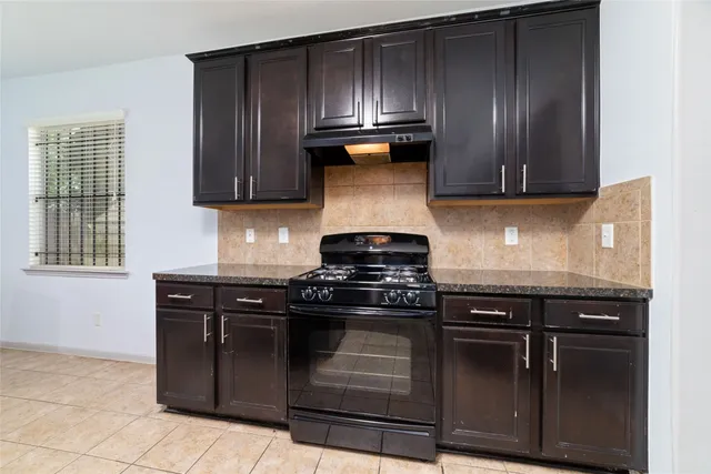 a kitchen with granite countertop wooden cabinets and stainless steel appliances