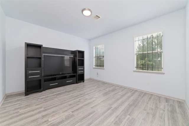 a living room with hardwood floor and flat screen tv