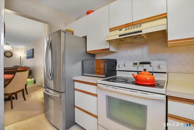 a kitchen with stainless steel appliances granite countertop a refrigerator and a stove