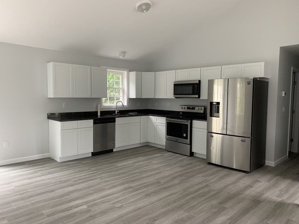 445 West Royalston Road Athol, MA 01331 - Photo 4 of 12 a kitchen with granite countertop a refrigerator and a stove top oven