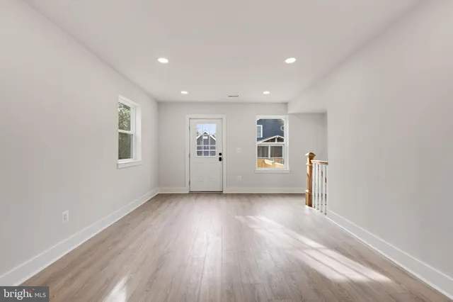 a view of an empty room with wooden floor