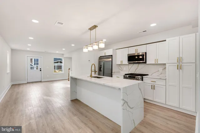 a kitchen with stainless steel appliances a refrigerator sink and microwave