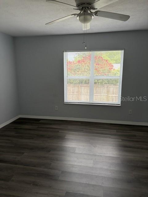610 Kirkland Circle Dunedin, FL 34698 - Photo 12 of 28 an empty room with wooden floor chandelier fan and windows