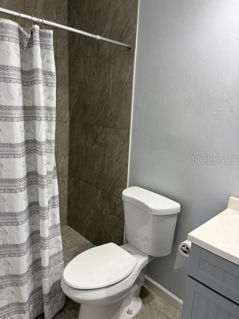610 Kirkland Circle Dunedin, FL 34698 - Photo 18 of 28 a white toilet sitting next to a shower curtain