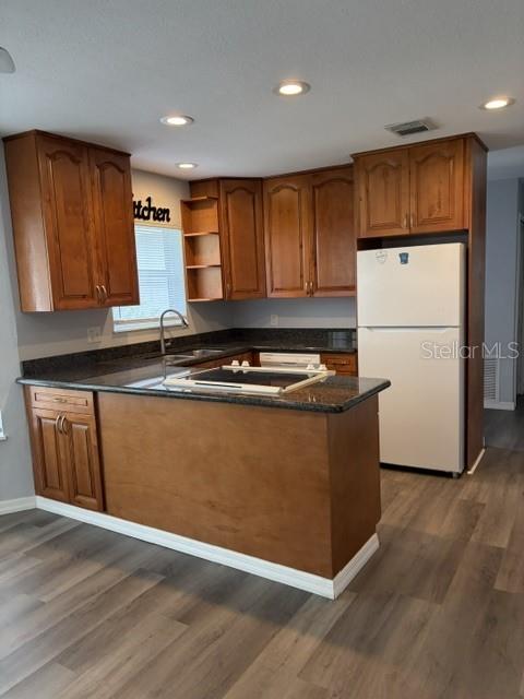 610 Kirkland Circle Dunedin, FL 34698 - Photo 21 of 28 a kitchen with wooden cabinets and a refrigerator