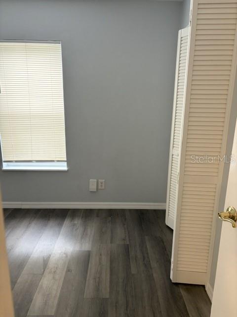 610 Kirkland Circle Dunedin, FL 34698 - Photo 7 of 28 an empty room with wooden floor and windows