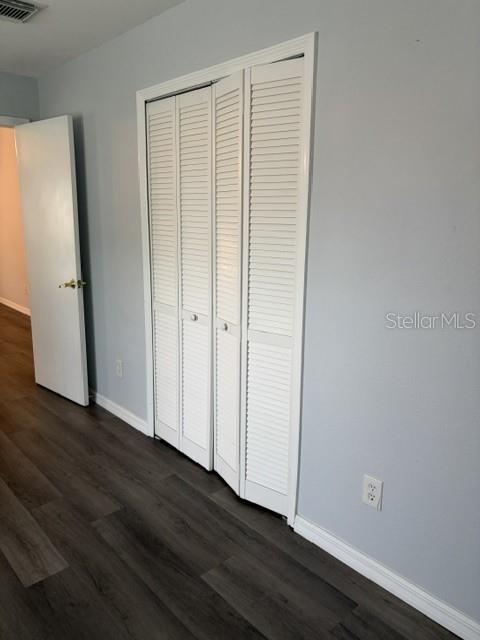 610 Kirkland Circle Dunedin, FL 34698 - Photo 8 of 28 an empty room with wooden floor and closet area