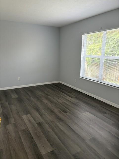 610 Kirkland Circle Dunedin, FL 34698 - Photo 10 of 28 an empty room with wooden floor and windows