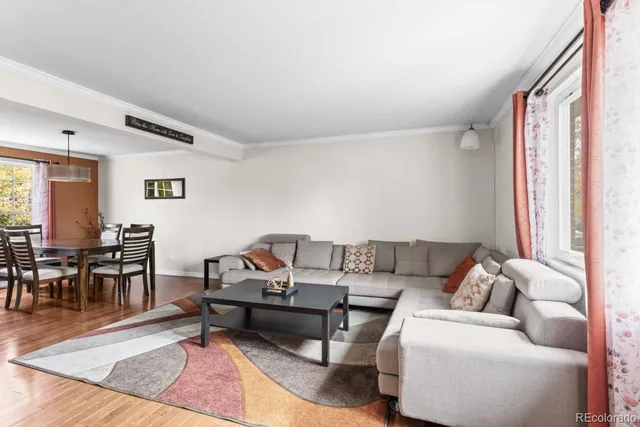 a living room with furniture a dining table and a window