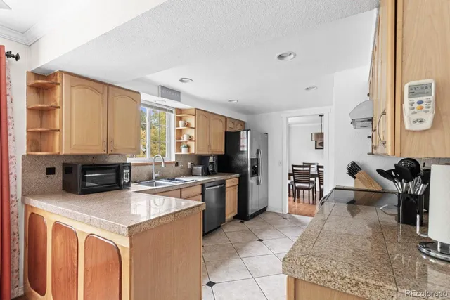 a kitchen with stainless steel appliances granite countertop a stove top oven a sink refrigerator and cabinets