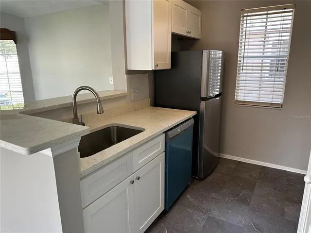 a kitchen with a sink cabinets and a window